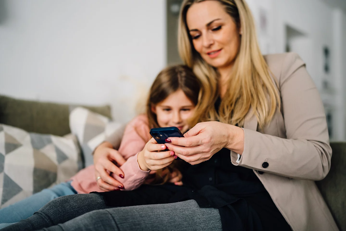 Frau mit Kind schauen auf ihr Smartphone