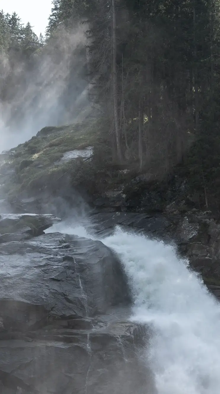 We look out over a waterfall, rocks and a mystical-looking forest.
